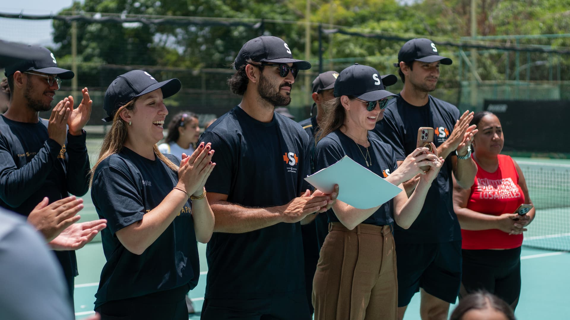 Equipo de TenniSapien aplaudiendo en la cancha