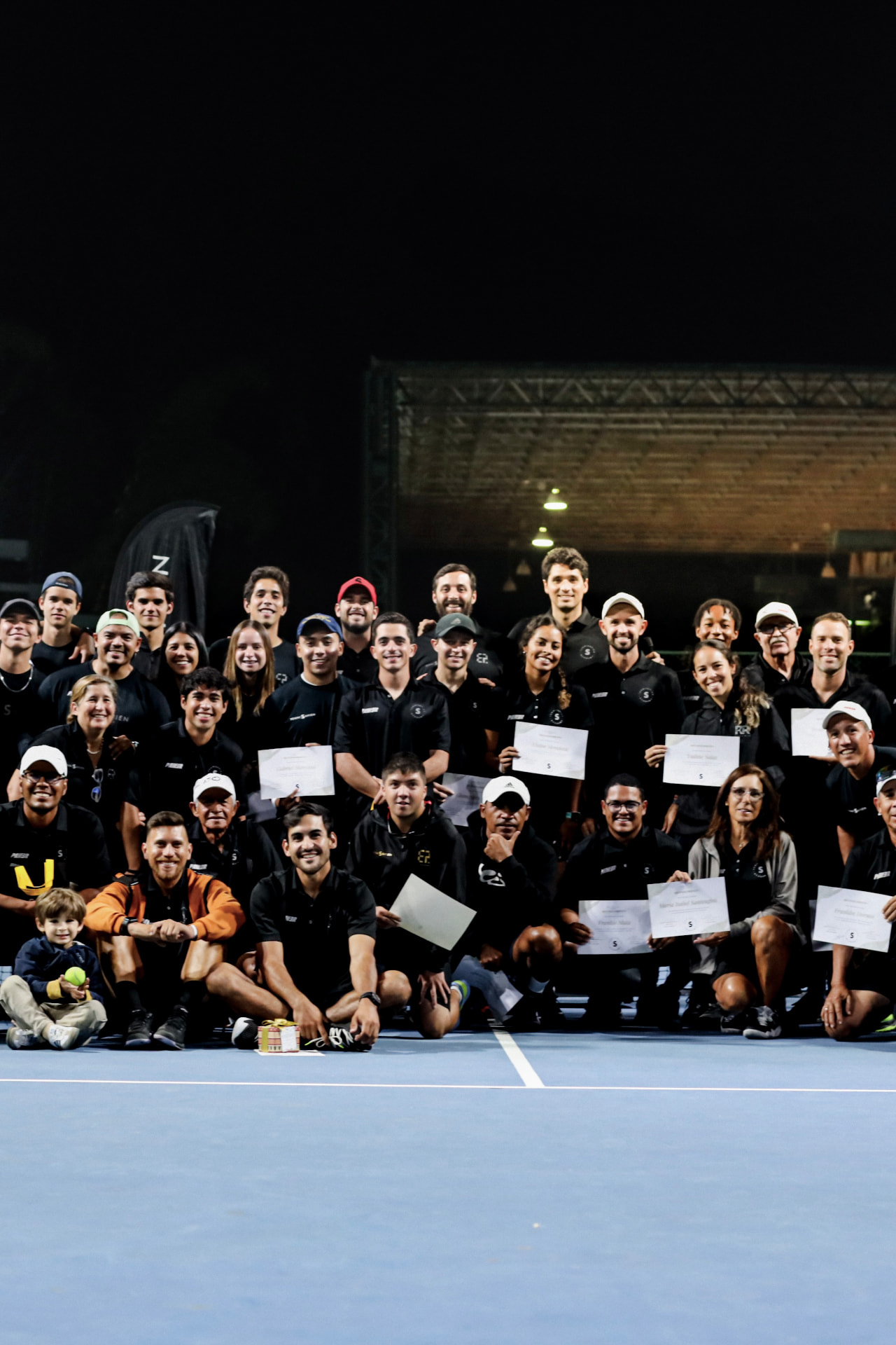 Equipo de entrenadores TenniSapien reunido en la cancha con sus certificados