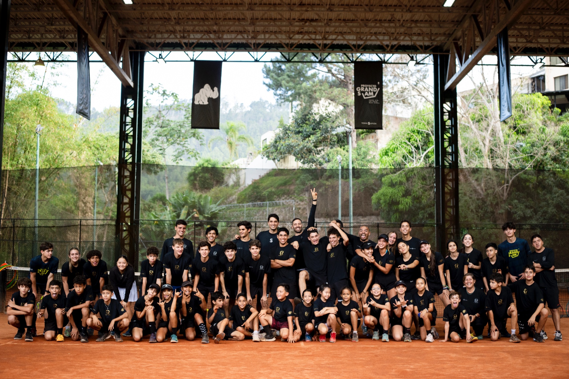 Equipo de Elite Performance, centro TenniSapien, posando junto al banner Grand Slam TenniSapien